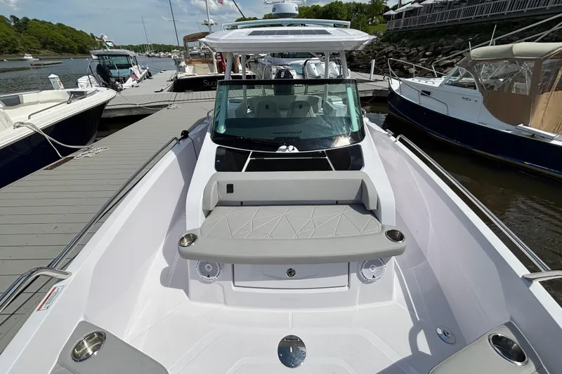 Slide: The Image of 2025 Axopar 29 Sun-Top boat docked, showcasing sleek design and spacious seating area. - 12
