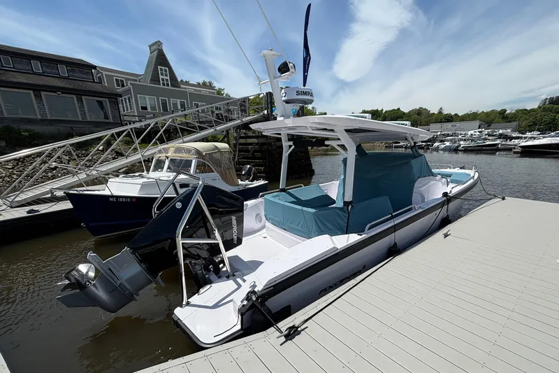 Slide: The Image of 2025 Axopar 29 Sun-Top boat docked at a marina under a clear sky. - 14