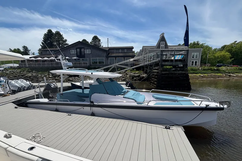 Slide: The Image of 2025 Axopar 29 Sun-Top boat docked at a marina under a clear blue sky. - 15