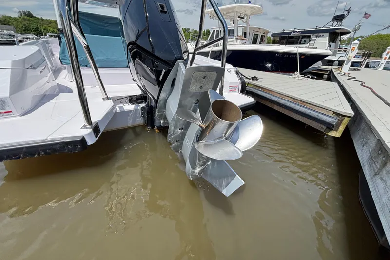 Slide: The Image of 2025 Axopar 29 Sun-Top boat with outboard motor and propeller at dockside. - 19