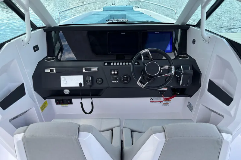 Slide: The Image of 2025 Axopar 29 Sun-Top boat cockpit with modern steering and navigation controls. - 21