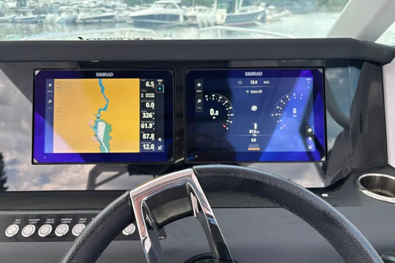 Slide: The Image of 2025 Axopar 29 Sun-Top dashboard with dual Simrad displays and steering wheel. - 22