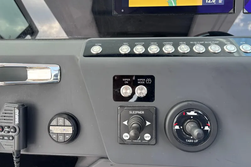 Slide: The Image of Control panel of 2025 Axopar 29 Sun-Top boat with various switches and dials. - 24