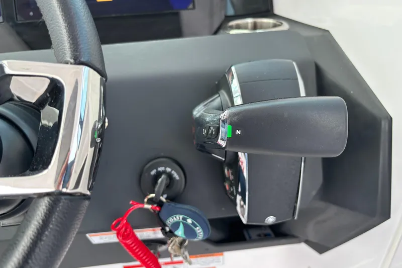 Slide: The Image of Close-up of 2025 Axopar 29 Sun-Top boat controls, featuring steering wheel and throttle lever. - 25