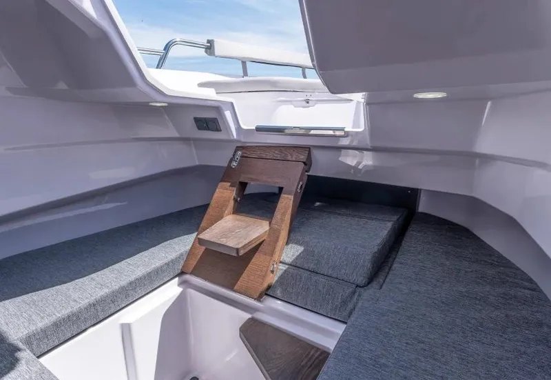 Slide: The Image of 2025 Axopar 29 Sun Top interior with wooden steps and cushioned seating. - 29