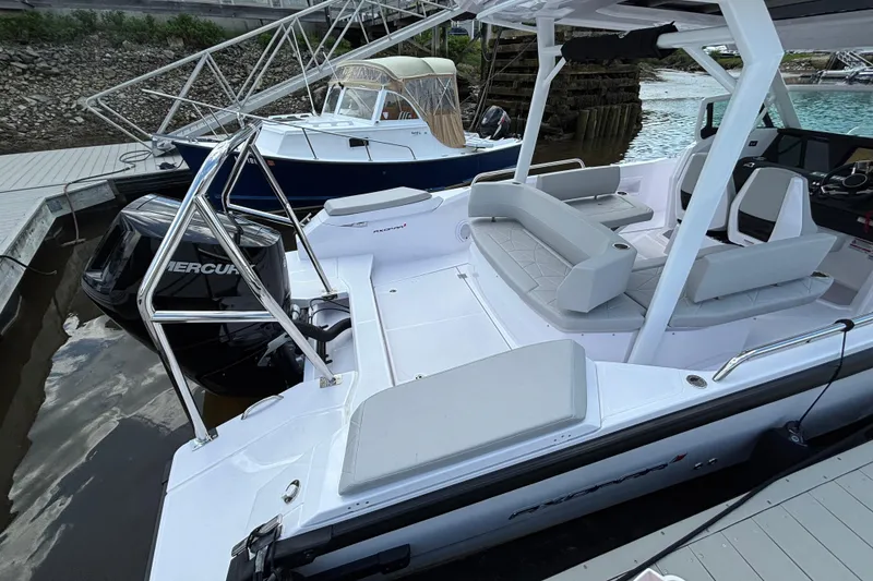 Slide: The Image of 2025 Axopar 29 Sun-Top boat docked, featuring spacious seating and Mercury outboard engine. - 4