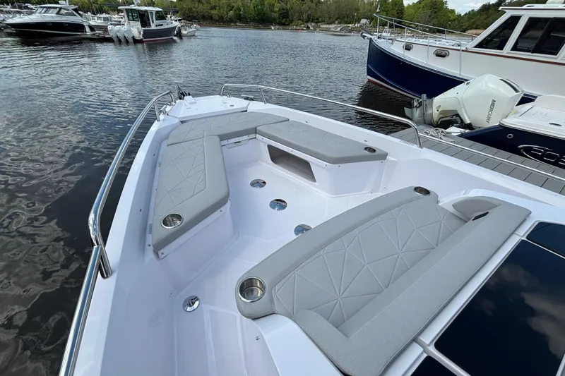 Slide: The Image of 2025 Axopar 29 Sun-Top boat with spacious seating, docked on a calm lake. - 8