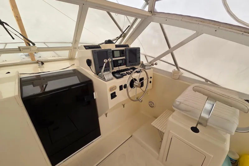 Slide: The Image of 2004 Carolina Classic 35 boat cockpit with steering wheel and navigation equipment. - 11