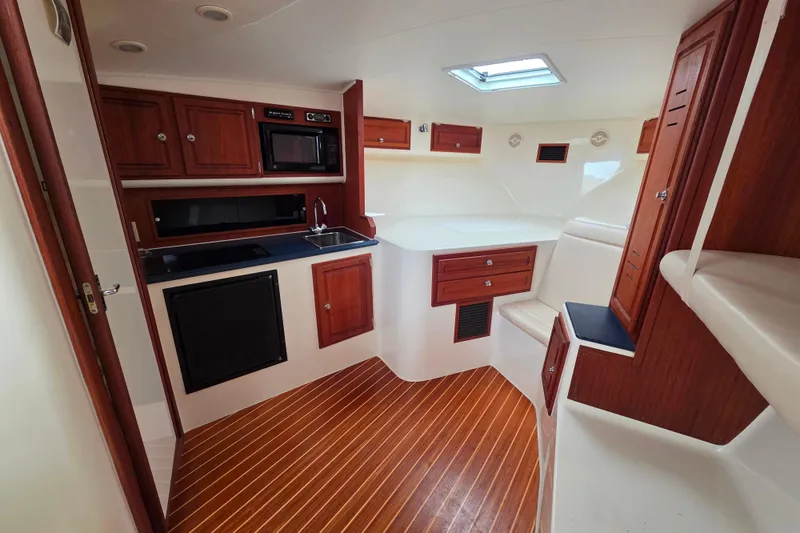 Slide: The Image of Interior of 2004 Carolina Classic 35 boat with wood cabinetry and compact kitchen area. - 15