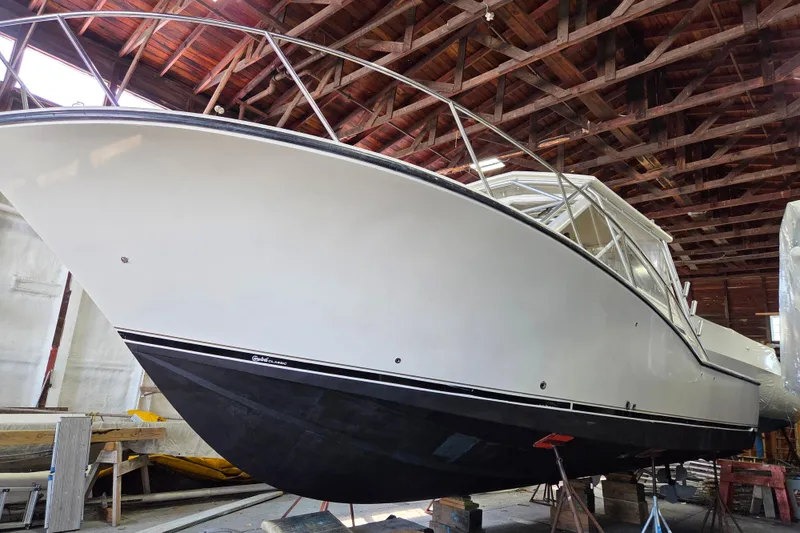 Slide: The Image of 2004 Carolina Classic 35 boat in a wooden boathouse, elevated on stands. - 2