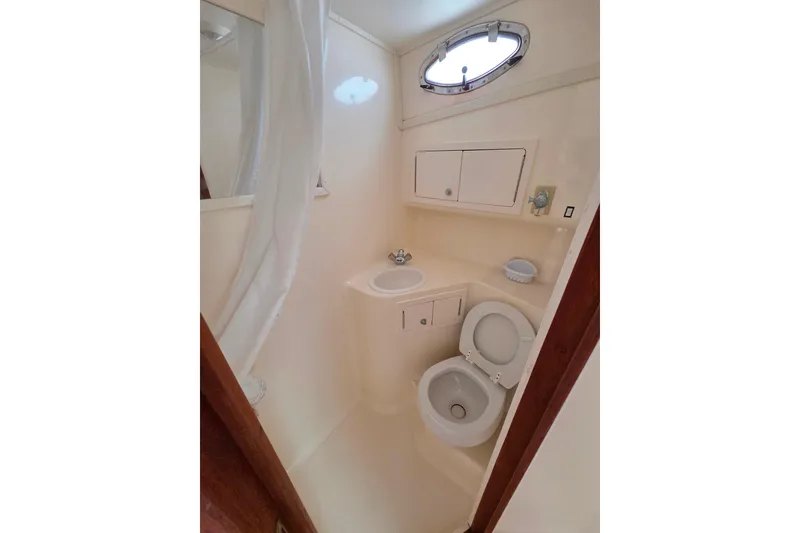 Slide: The Image of Bathroom interior of 2004 Carolina Classic 35 boat, featuring toilet, sink, and storage cabinets. - 20