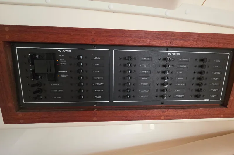 Slide: The Image of Electrical control panel on a 2004 Carolina Classic 35 boat, featuring AC and DC power switches. - 23