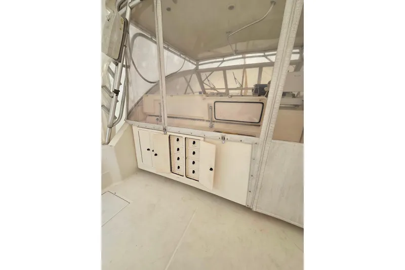 Slide: The Image of 2004 Carolina Classic 35 boat interior with storage compartments and clear enclosure. - 6