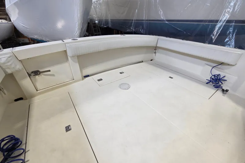 Slide: The Image of 2004 Carolina Classic 35 boat deck with storage compartments and coiled blue hose. - 7