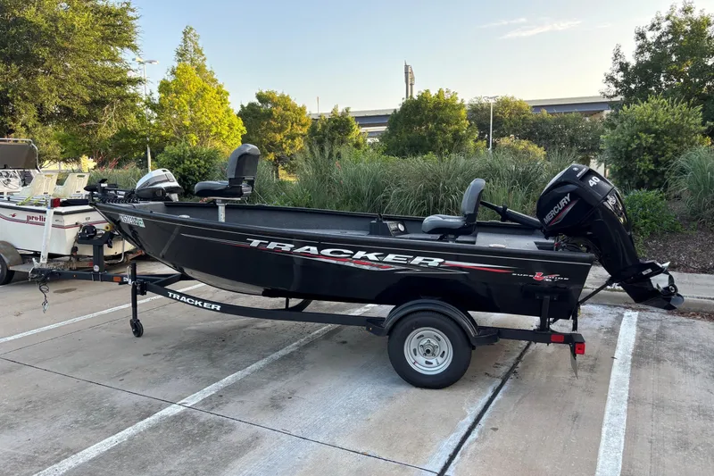 The Image of 2025 Tracker Super Guide V-16 T boat with Mercury engine in parking lot. - 0