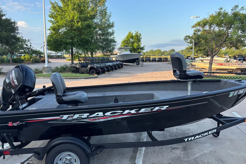 Slide: The Image of 2025 Tracker Super Guide V-16 T boat on trailer in parking lot. - 2
