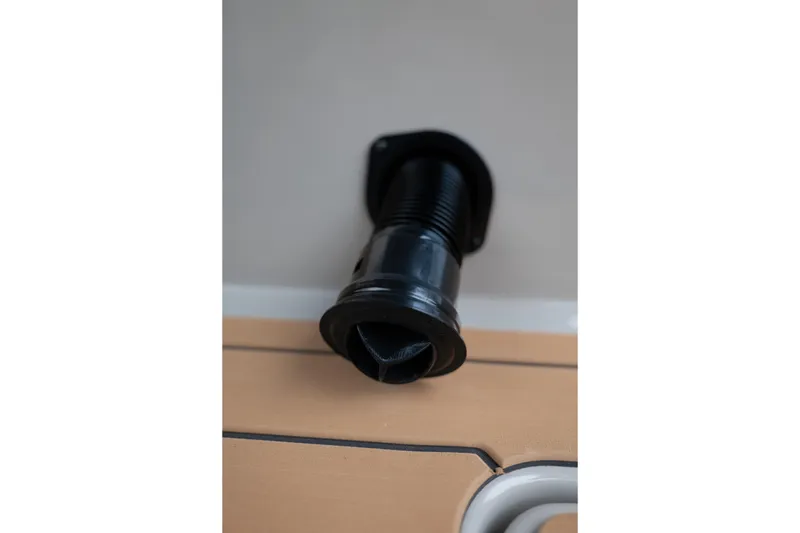 Slide: The Image of Close-up of a 2026 MasterCraft X24 boat component, featuring a black fitting on a wooden surface. - 26