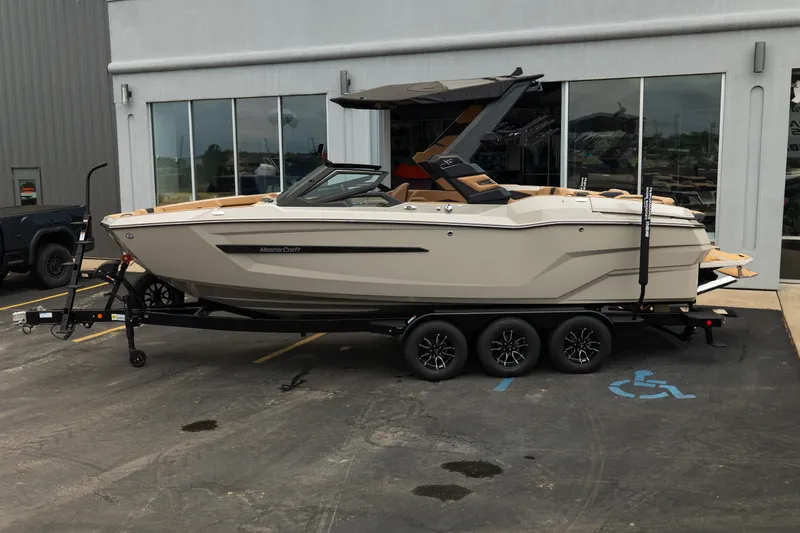 Slide: The Image of 2026 MasterCraft X24 boat on trailer outside dealership. - 3