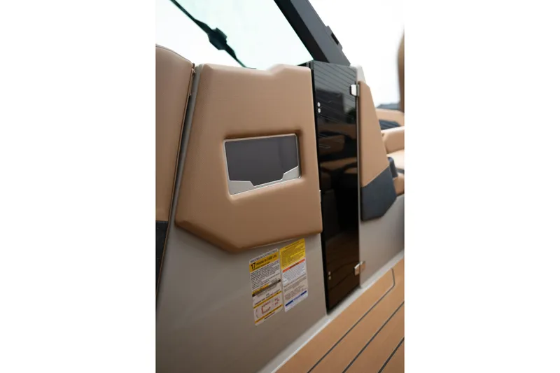 Slide: The Image of 2026 MasterCraft X24 boat interior with tan upholstery and safety labels. - 36