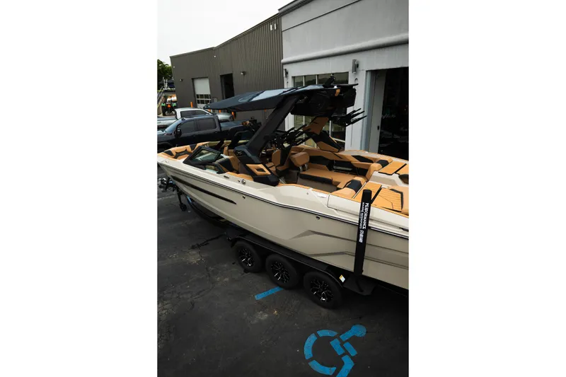 Slide: The Image of 2026 MasterCraft X24 boat on trailer, parked outside a building. - 5