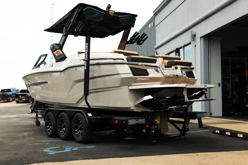 Slide: The Image of 2026 MasterCraft X24 boat on trailer, parked outside a building. - 7