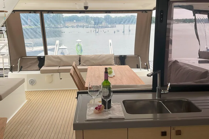 Slide: The Image of Interior view of 2017 Fountaine Pajot Lucia 40 catamaran with dining area and scenic water backdrop. - 3