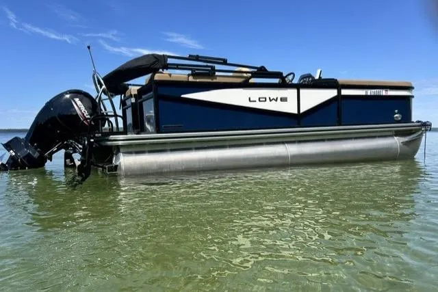 Slide: The Image of 2025 Lowe SS 210 WT pontoon boat on clear water under blue sky. - 2