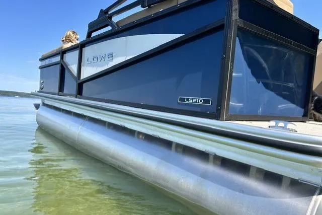 Slide: The Image of 2025 Lowe SS 210 WT pontoon boat on calm water, side view. - 3