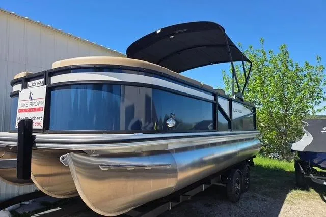 Slide: The Image of 2025 Lowe SS 210 WT pontoon boat with canopy, parked outdoors under clear blue sky. - 4