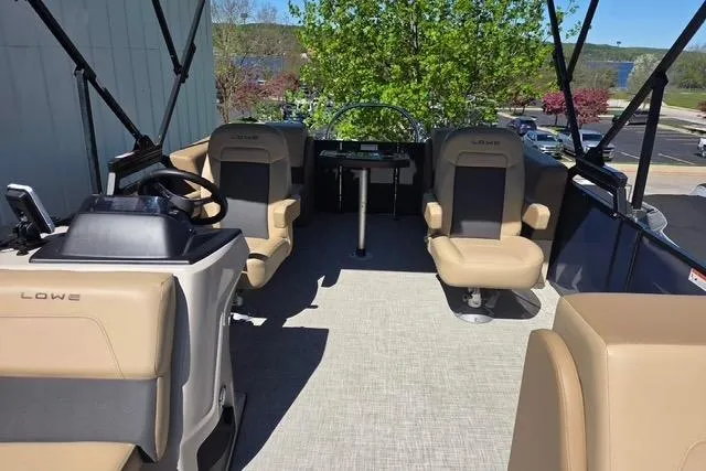 Slide: The Image of 2025 Lowe SS 210 WT boat interior with beige seating and steering console. - 5