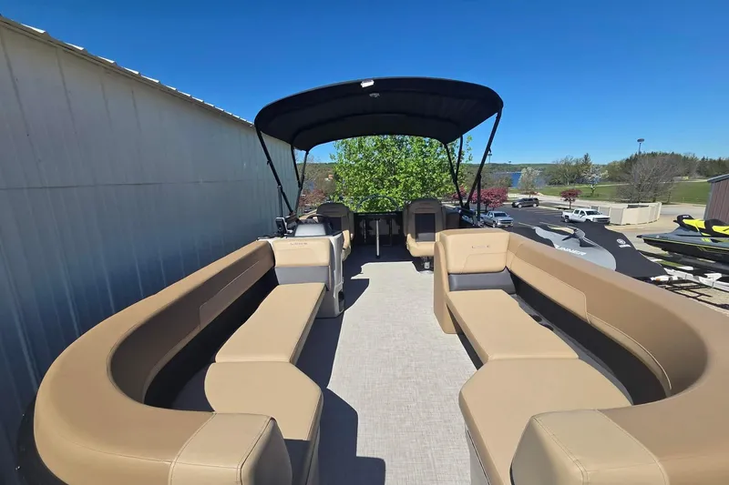 Slide: The Image of 2025 Lowe SS 210 WT pontoon boat with spacious seating and canopy under clear blue sky. - 6