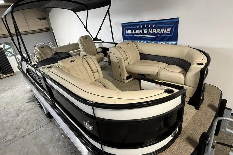 Slide: The Image of 2020 Barletta L23UC pontoon boat with beige seating, showcased indoors at Miller's Marine. - 2