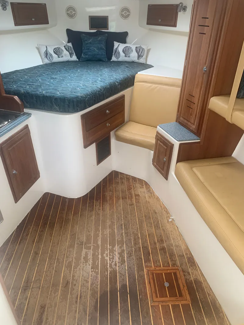 Slide: The Image of Interior of a 2003 Carolina Classic Express with wooden floor and bed. - 2