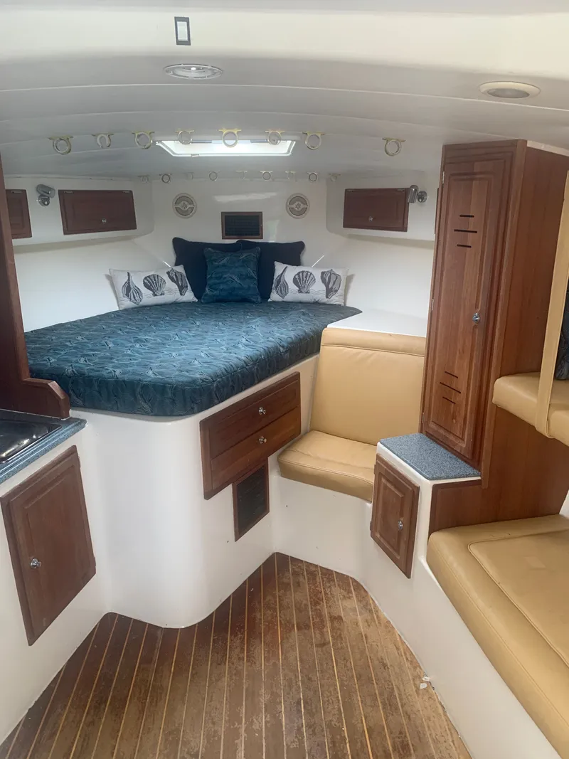 Slide: The Image of Interior of a 2003 Carolina Classic Express yacht with bed and seating area. - 33