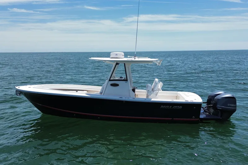 Slide: The Image of 2020 Regulator 28 boat on calm ocean waters under a clear blue sky. - 4