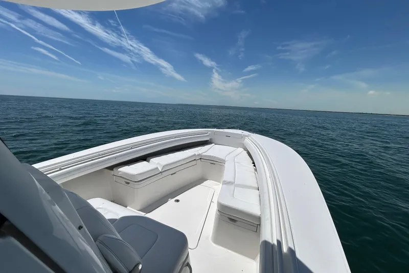 Slide: The Image of 2020 Regulator 28 boat with white seating, cruising on open ocean under clear blue sky. - 6