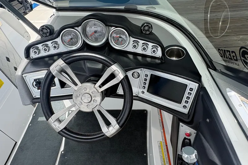 Slide: The Image of 2016 MasterCraft X26 boat dashboard with steering wheel and control panel. - 6