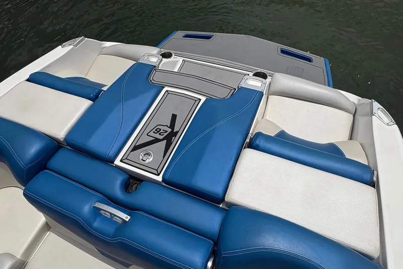 Slide: The Image of 2016 MasterCraft X26 boat interior with blue and white seating on water. - 7