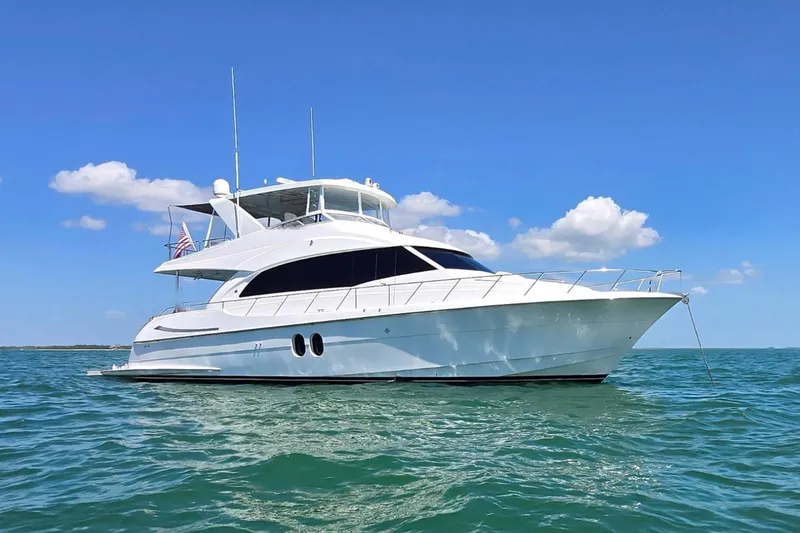 Slide: The Image of 2009 Hatteras 60 Motor Yacht on calm blue waters under clear sky. - 1