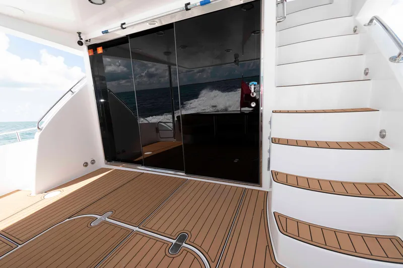 Slide: The Image of 2009 Hatteras 60 Motor Yacht deck with teak flooring and curved staircase. - 11