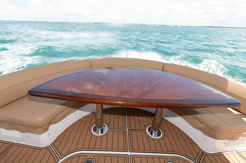 Slide: The Image of Luxurious 2009 Hatteras 60 Motor Yacht deck with elegant wood table and ocean view. - 14