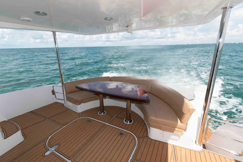 Slide: The Image of Luxurious 2009 Hatteras 60 Motor Yacht deck with ocean view and elegant seating. - 15