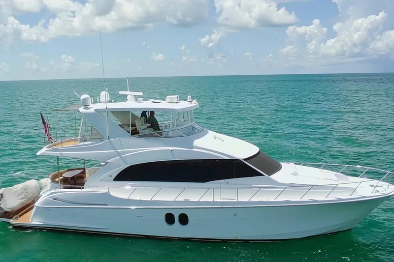 Slide: The Image of 2009 Hatteras 60 Motor Yacht cruising on clear blue ocean waters. - 2