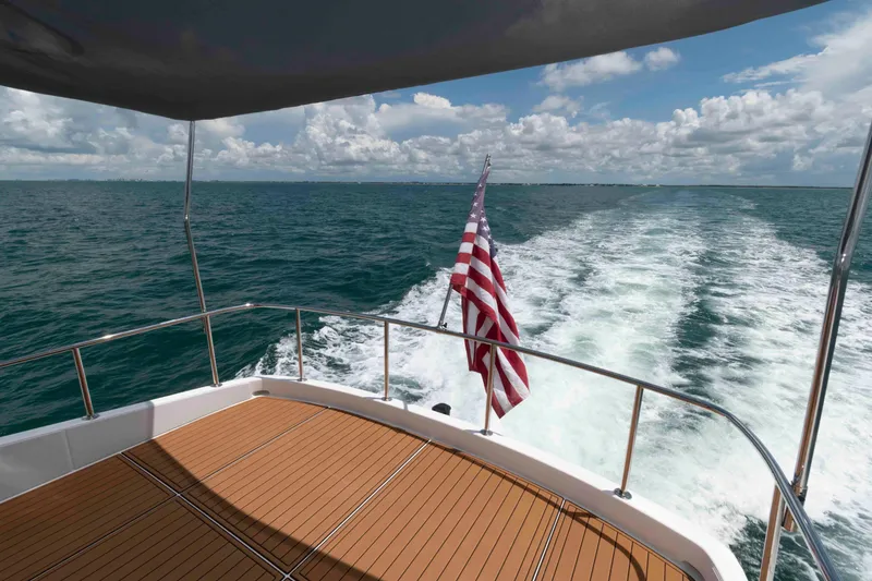 Slide: The Image of Aft deck view of 2009 Hatteras 60 Motor Yacht cruising on open sea. - 26