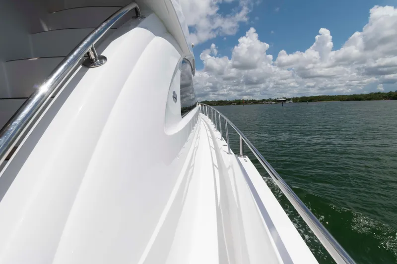 Slide: The Image of 2009 Hatteras 60 Motor Yacht side view, cruising on calm waters under a partly cloudy sky. - 28