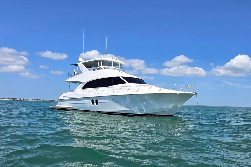 Slide: The Image of 2009 Hatteras 60 Motor Yacht cruising on open water under a clear blue sky. - 3