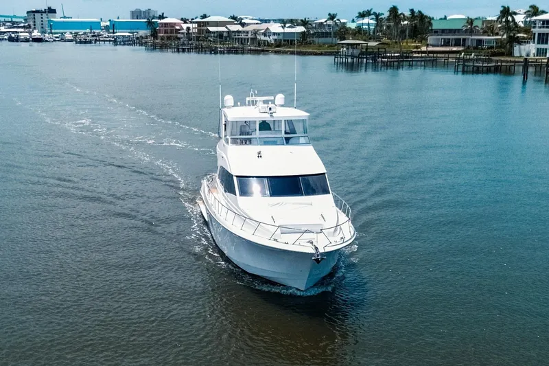 Slide: The Image of 2009 Hatteras 60 Motor Yacht cruising in a serene coastal setting. - 6