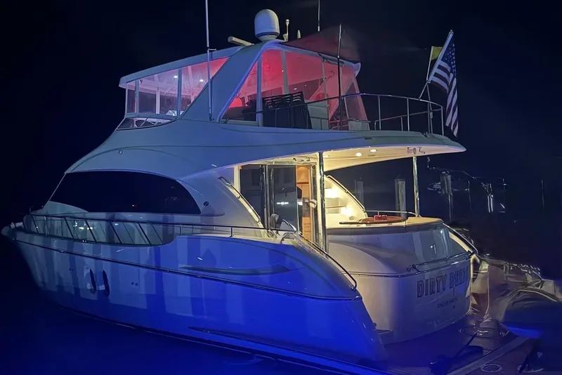 Slide: The Image of 2009 Hatteras 60 Motor Yacht illuminated at night with American flag. - 9
