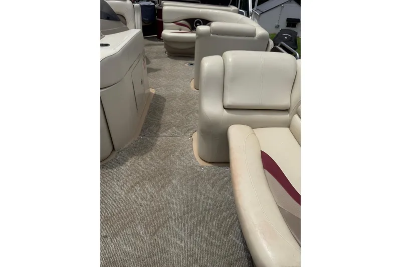 Slide: The Image of 2008 Sylvan 8523 Mandalay RE boat interior with beige seating and carpet flooring. - 18