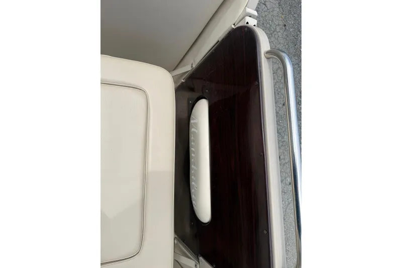 Slide: The Image of 2008 Sylvan 8523 Mandalay RE boat interior with beige seating and dark wood accents. - 22
